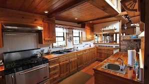 A kitchen with wooden cabinets, a stove, and a sink.