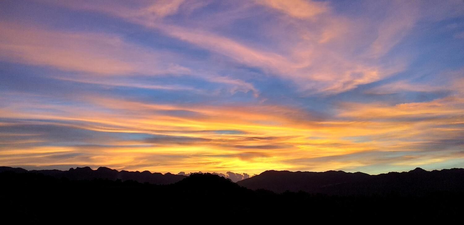 A sunset over a mountain range with a clear sky.