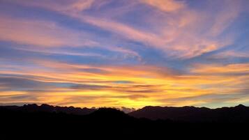 A sunset over a mountain range with a clear sky.
