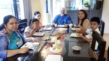 A family dining at a table with various dishes and condiments.