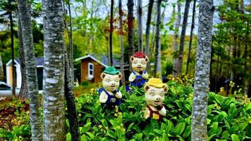 A forested area with three small figurines on a bed of green foliage.