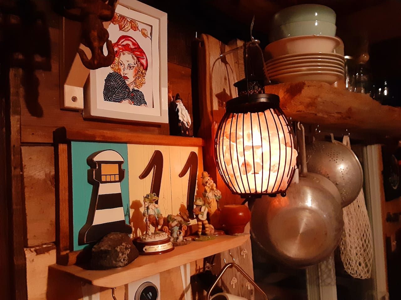 A shelf with a lighthouse cutout, a number '11', and various figurines.
