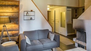 Een moderne woonkamer met een grijze bank, een lamp en een open haard.