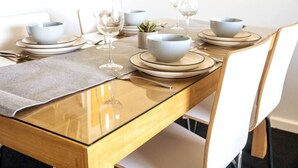 A dining table set with plates, bowls, glasses, and cutlery. - Wake up to sweeping harbour views in this modern, split-level apartment located between Fishing Boat Harbour and Challenger Harbour. Whether you're a couple, a family, or here on business, this peaceful retreat offers the best of coastal charm and ci (Fremantle)