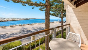 A balcony with a view of the sea, a chair, and a table. - Wake up to sweeping harbour views in this modern, split-level apartment located between Fishing Boat Harbour and Challenger Harbour. Whether you're a couple, a family, or here on business, this peaceful retreat offers the best of coastal charm and ci (Fremantle)
