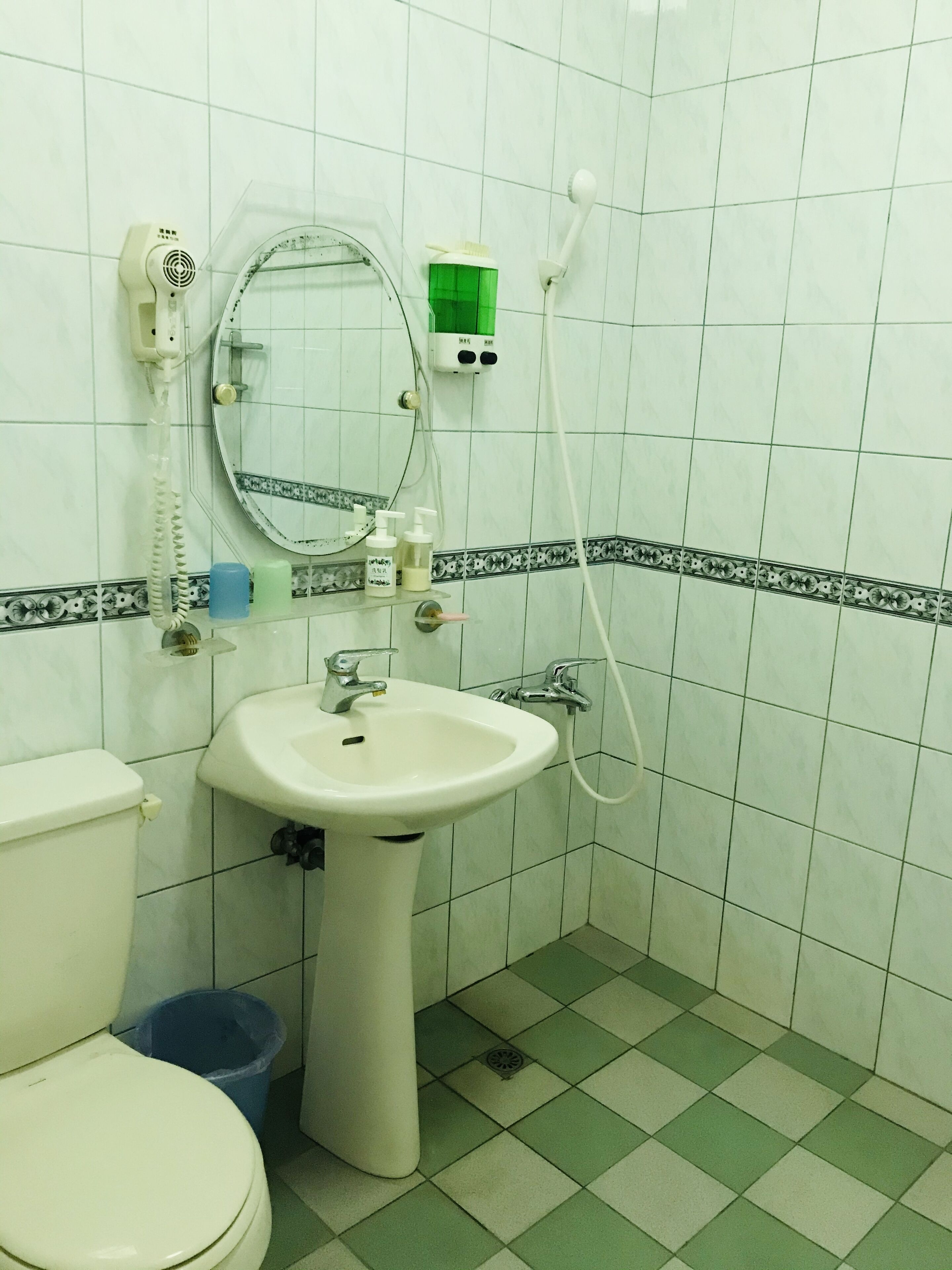 A bathroom with a toilet, sink, and shower.