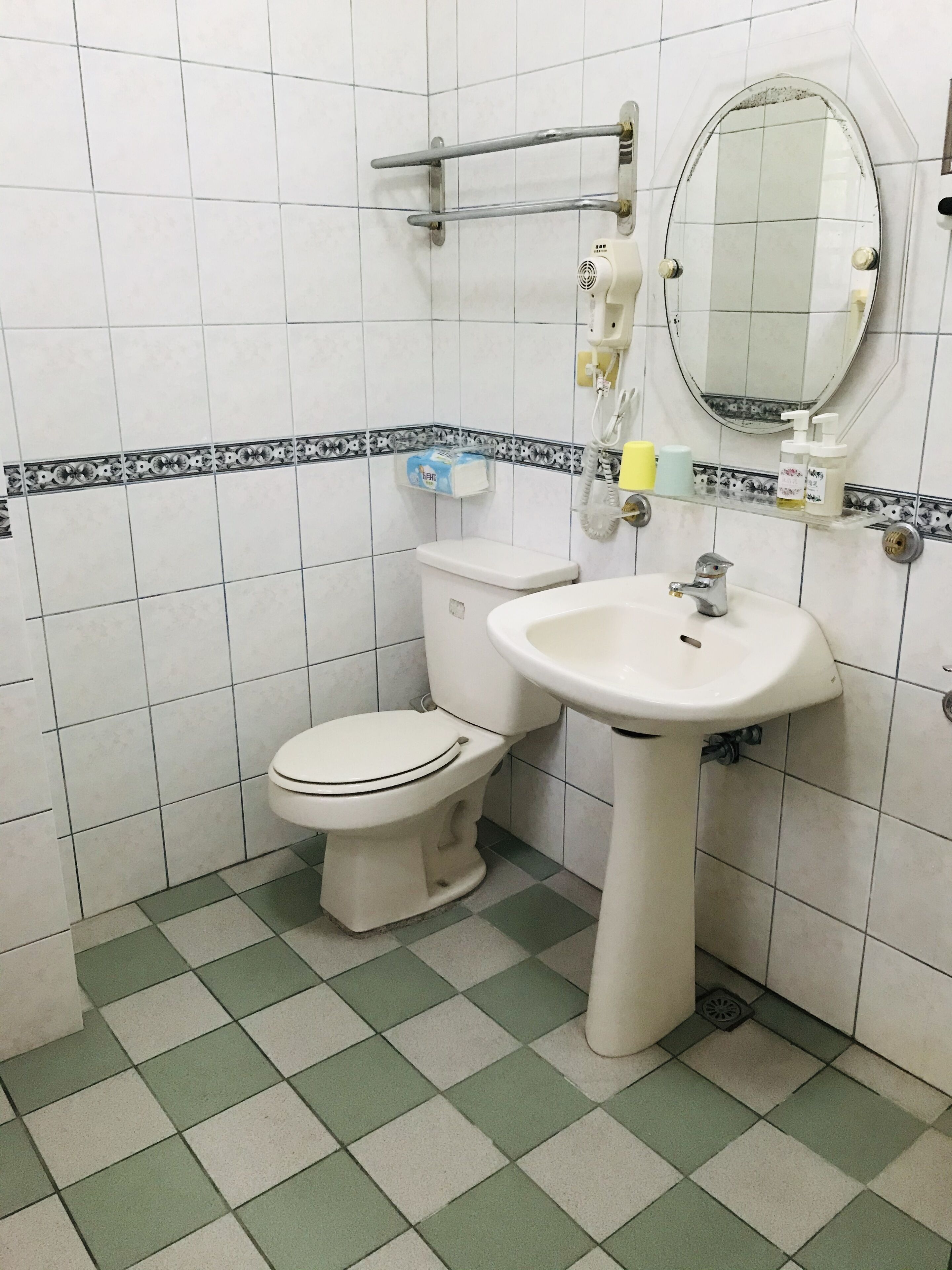 Un baño pequeño con inodoro, lavamanos y espejo.