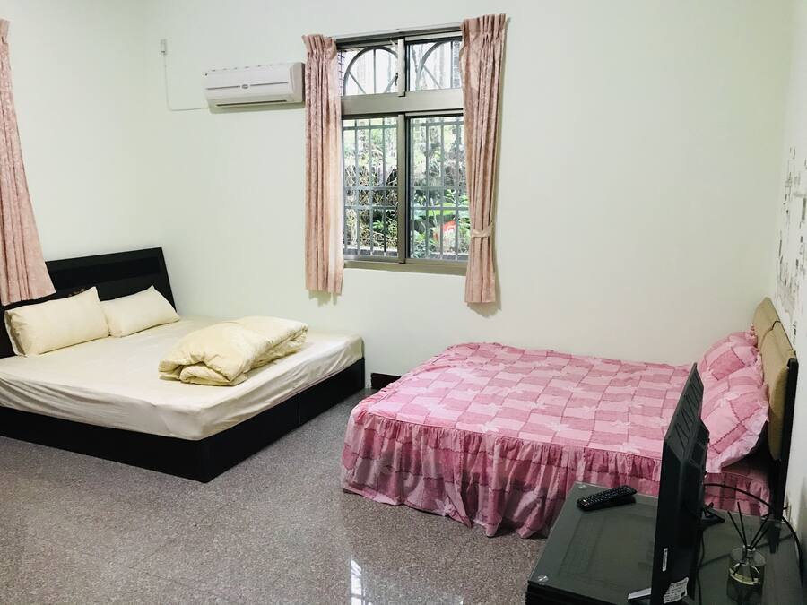 Un dormitorio con dos camas, televisión y aire acondicionado.
