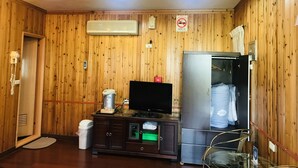 A wooden-paneled room with a television, a refrigerator, a cabinet, a trash bin, and a no-smoking sign. - Hua Yi Homestay (Gukeng)