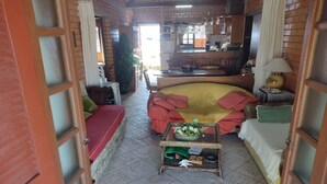 Ein gemütliches Wohnzimmer mit einer Couch, einem Couchtisch und einer Küchenzeile im Hintergrund.