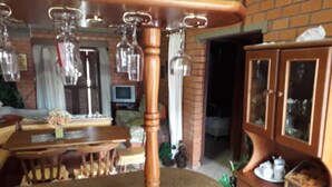 Ein Essbereich mit Holztisch und Stühlen, einem Schrank mit Glastüren und Pendelleuchten.