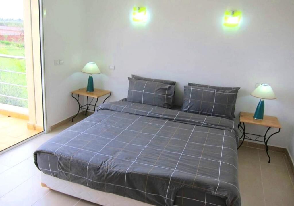 Ein Schlafzimmer mit einem großen Bett, zwei Nachttischen und zwei Wandlampen.