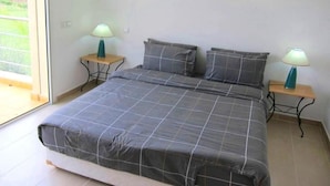 Ein Schlafzimmer mit einem großen Bett, zwei Nachttischen und zwei Wandlampen.