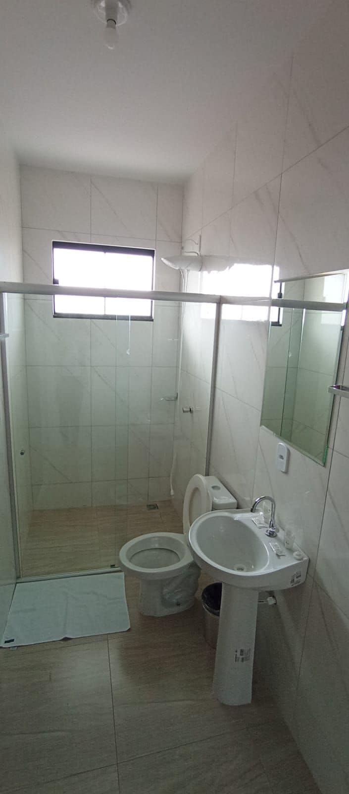 A bathroom with a shower, toilet, and sink.
