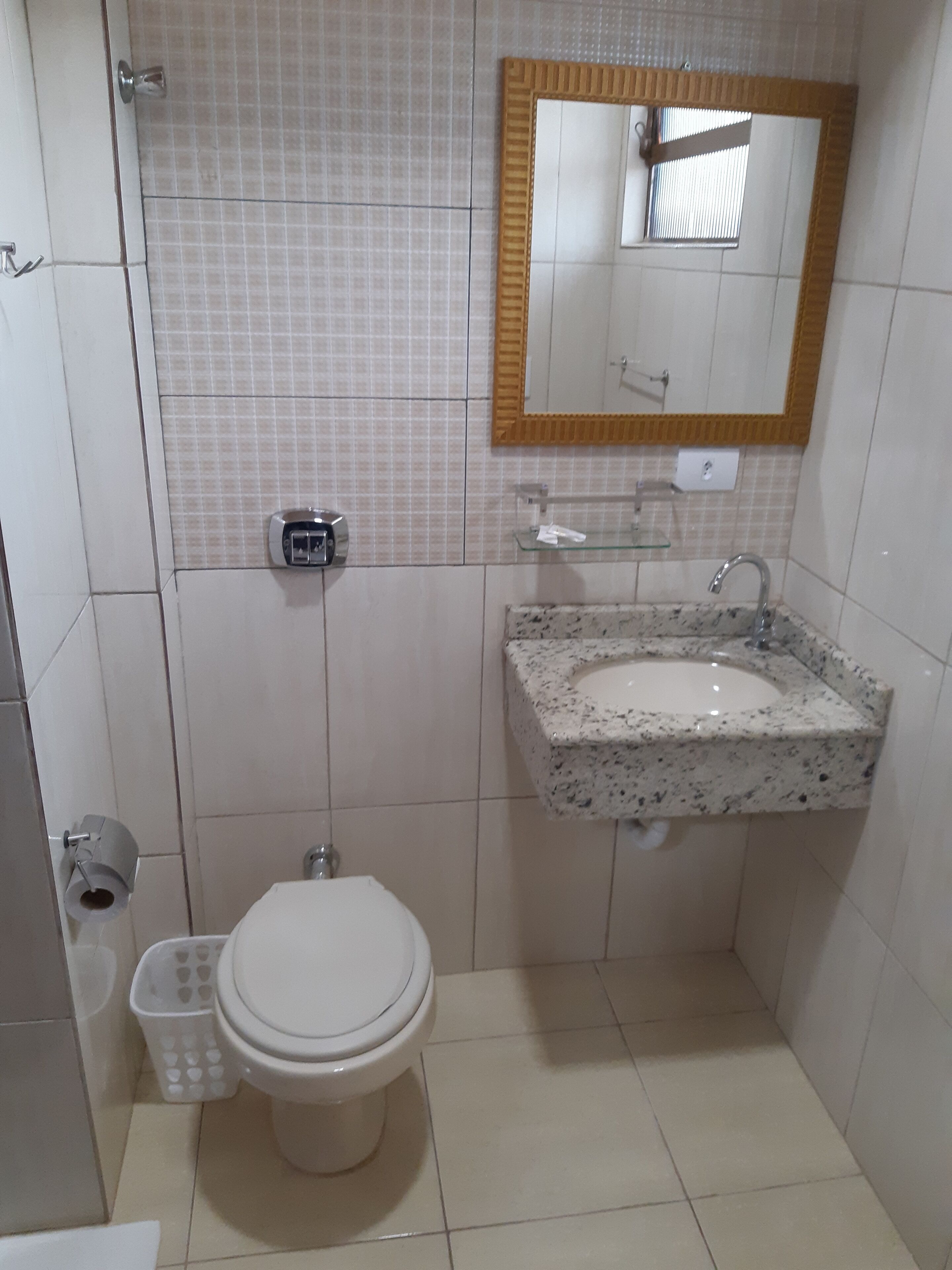 Un baño pequeño con inodoro, lavabo y espejo.