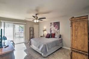 A bedroom with a bed, a ceiling fan, a wooden wardrobe, a desk with a chair, and a window with curtains. - Game Room, Fire Pit & Putting Green: Glendale Home (Glendale)