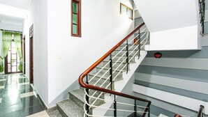 A staircase with a wooden handrail and metal balusters, leading to an upper floor.