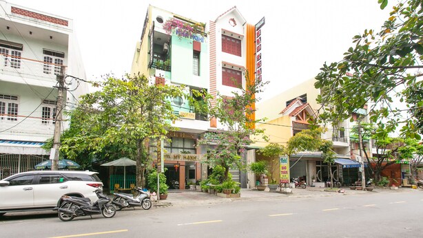 A street view with a building that has a sign reading "MY MANHDAI" and another sign that says "SPOT ONE".