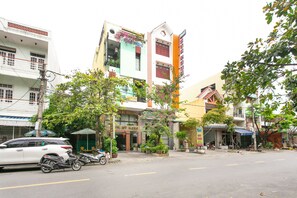 A street view with a building that has a sign reading "MY MANHDAI" and another sign that says "SPOT ONE". - SPOT ON 804 My Hanh Hotel (Da Nang)