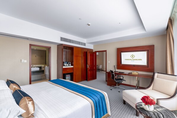 A hotel room with a bed, a desk, a chair, and a TV displaying the hotel name. - Yangon Thanlwin Hotel (Yangon)