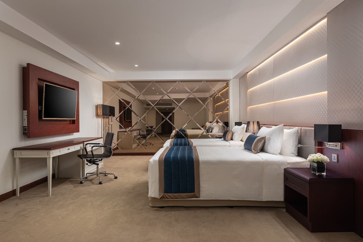 A modern hotel room with a bed, desk, and TV.