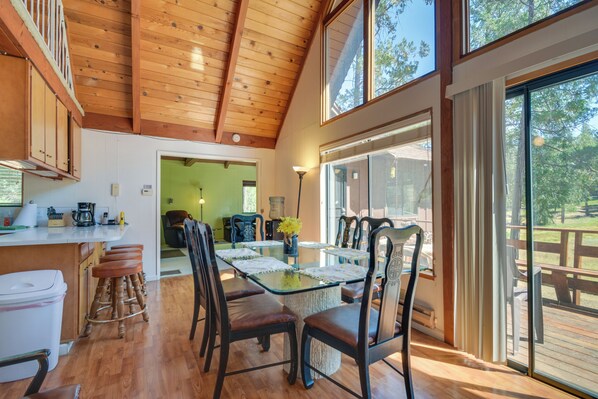 A spacious dining area with a glass-top table, wooden chairs, and a view of the outdoors. - 6 Mi to Yosemite Nat'l Park: 14-Acre Retreat! (Groveland)