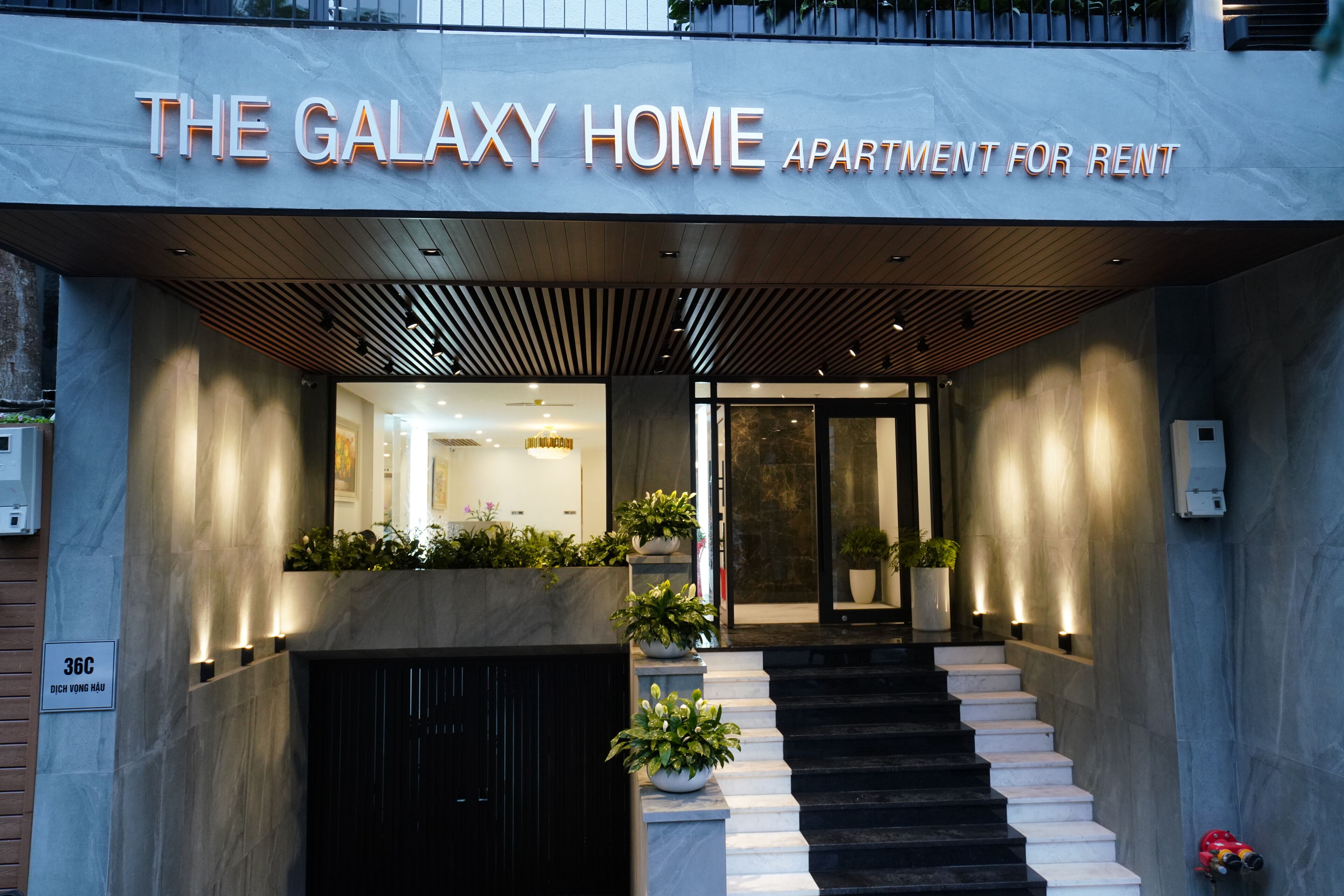A modern apartment building entrance with a sign reading "The Galaxy Home Apartment for Rent."