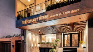 A modern apartment building with a sign reading "The Galaxy Home Apartment for Rent".