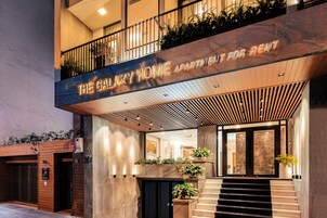 Un moderno edificio de apartamentos con un cartel que dice 'The Galaxy Home Apartment for Rent'.