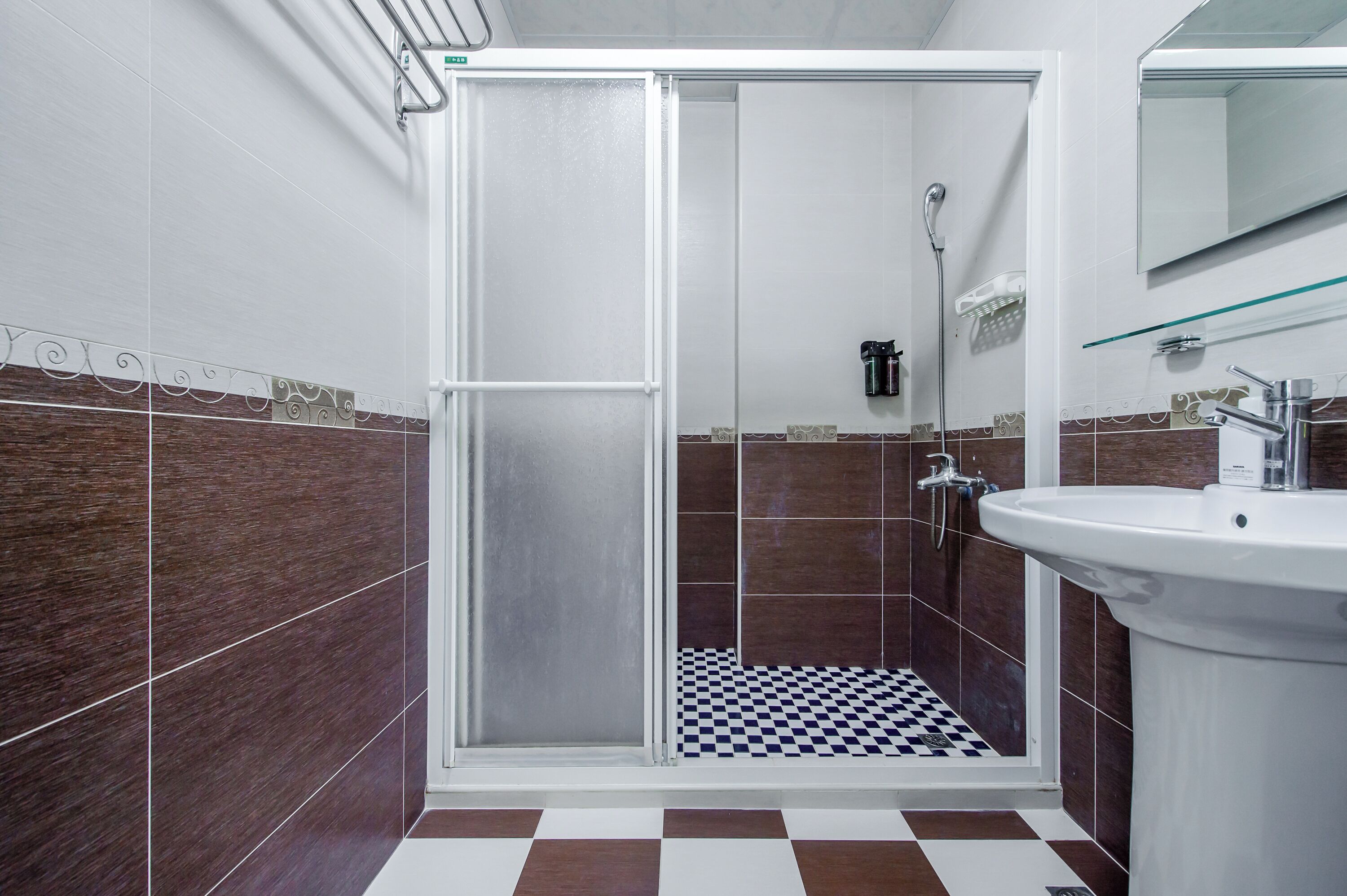 Une salle de bain avec une douche, un lavabo et un miroir.