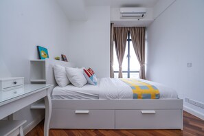 A modern bedroom with a bed, bedside table, and a desk.