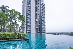 A high-rise building with a swimming pool in the foreground.