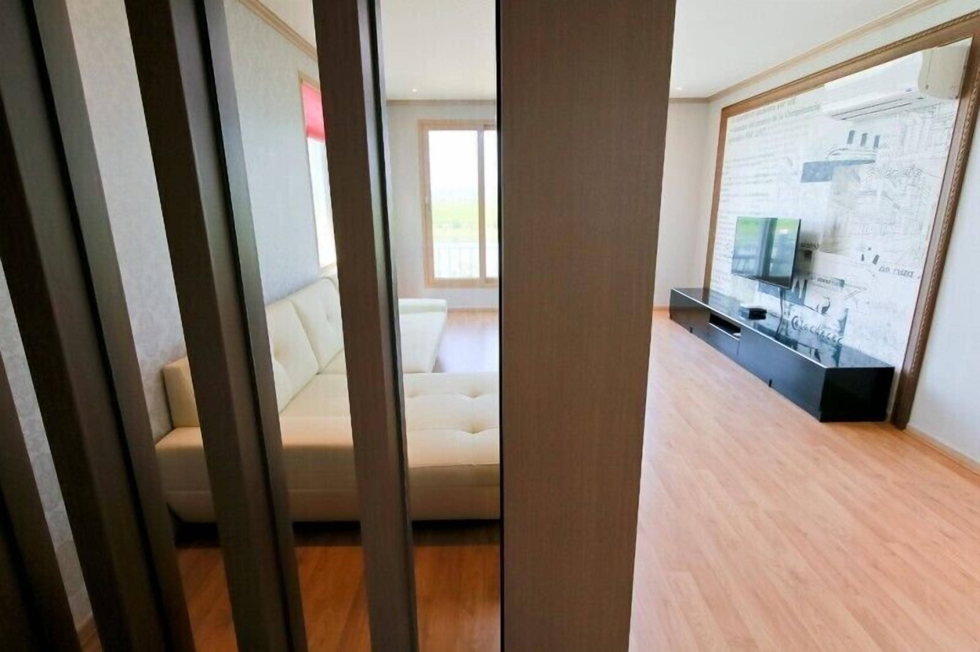 A modern living room with a sofa, a flat-screen TV, and a wall-mounted cabinet.