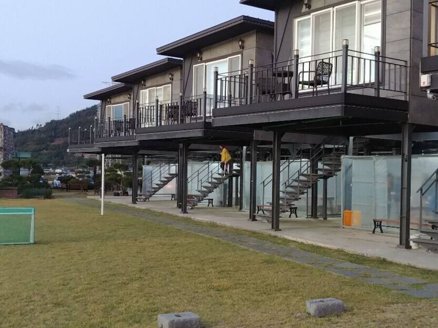 A modern building with multiple balconies and a well-maintained lawn.