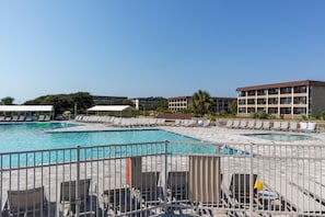 Relax by the pool surrounded by comfortable lounge chairs and umbrellas.