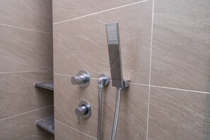 Eine Dusche mit Handbrause und Wandarmatur.