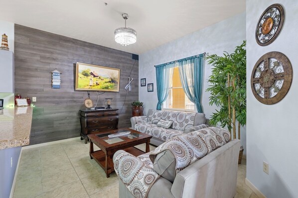 A living room with a sofa set, a coffee table, a wooden cabinet, and a painting on the wall.