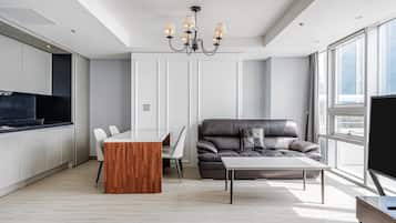 A modern living room with a dining area, a large window, and a flat-screen TV.