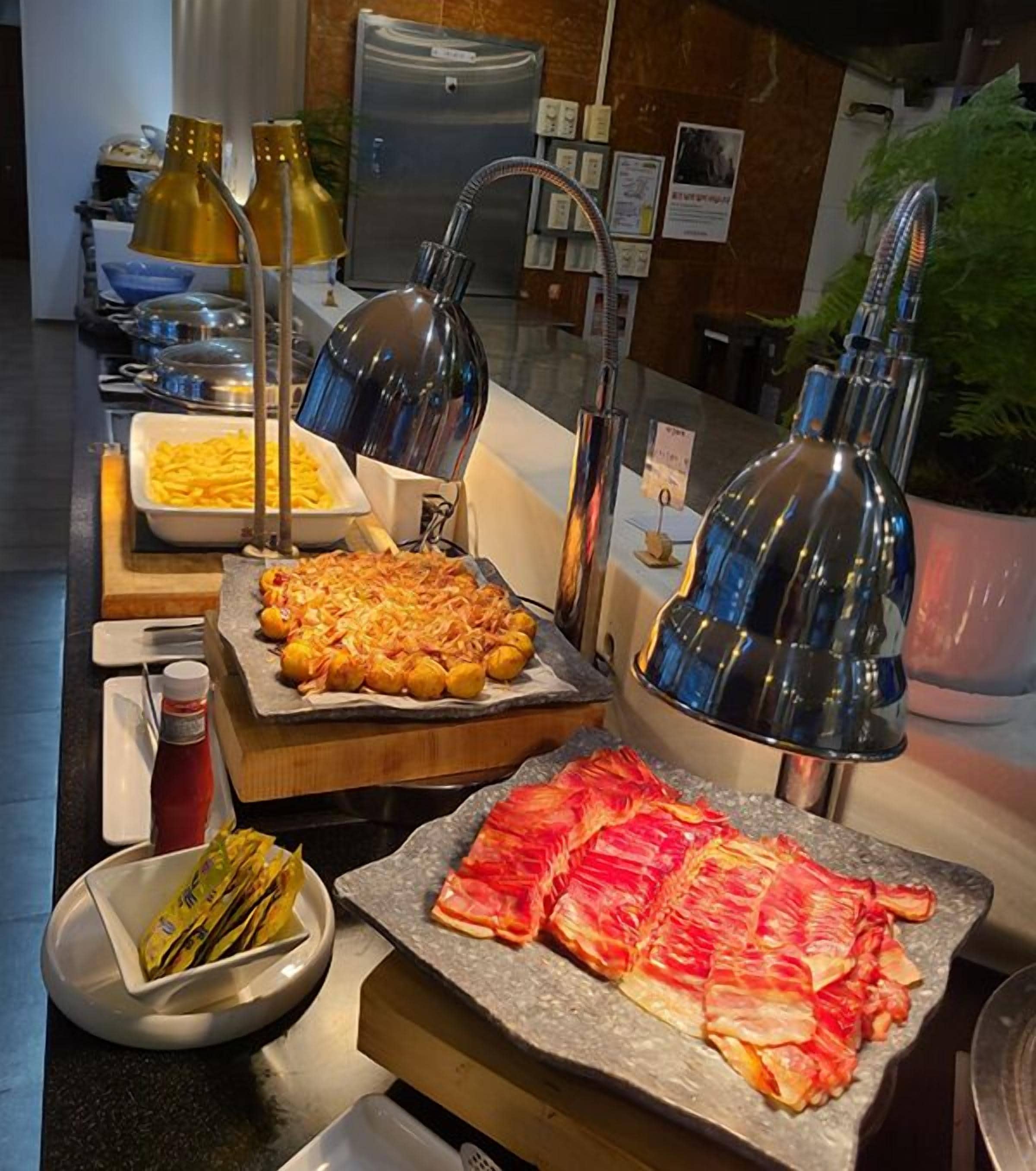 Un buffet proposant une variété de plats, avec en arrière-plan un espace cuisine moderne.