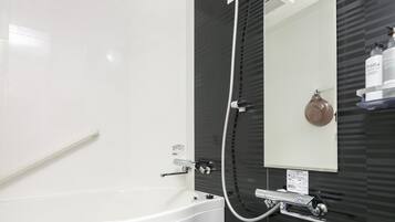 A modern bathroom with a freestanding bathtub, a wall-mounted mirror, and a showerhead.