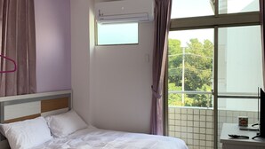 Une chambre à coucher avec un lit, un bureau et une fenêtre avec des rideaux.