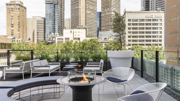 A rooftop terrace with outdoor seating, a fire pit, and a city skyline view. - Lancemore Crossley St Melbourne (Melbourne)