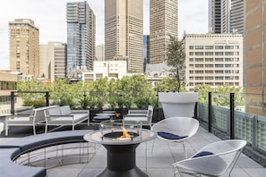 A rooftop terrace with outdoor seating, a fire pit, and a city skyline view. - Lancemore Crossley St Melbourne (Melbourne)
