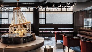 A modern interior with a central chandelier, seating areas, and large windows. - Lancemore Crossley St Melbourne (Melbourne)