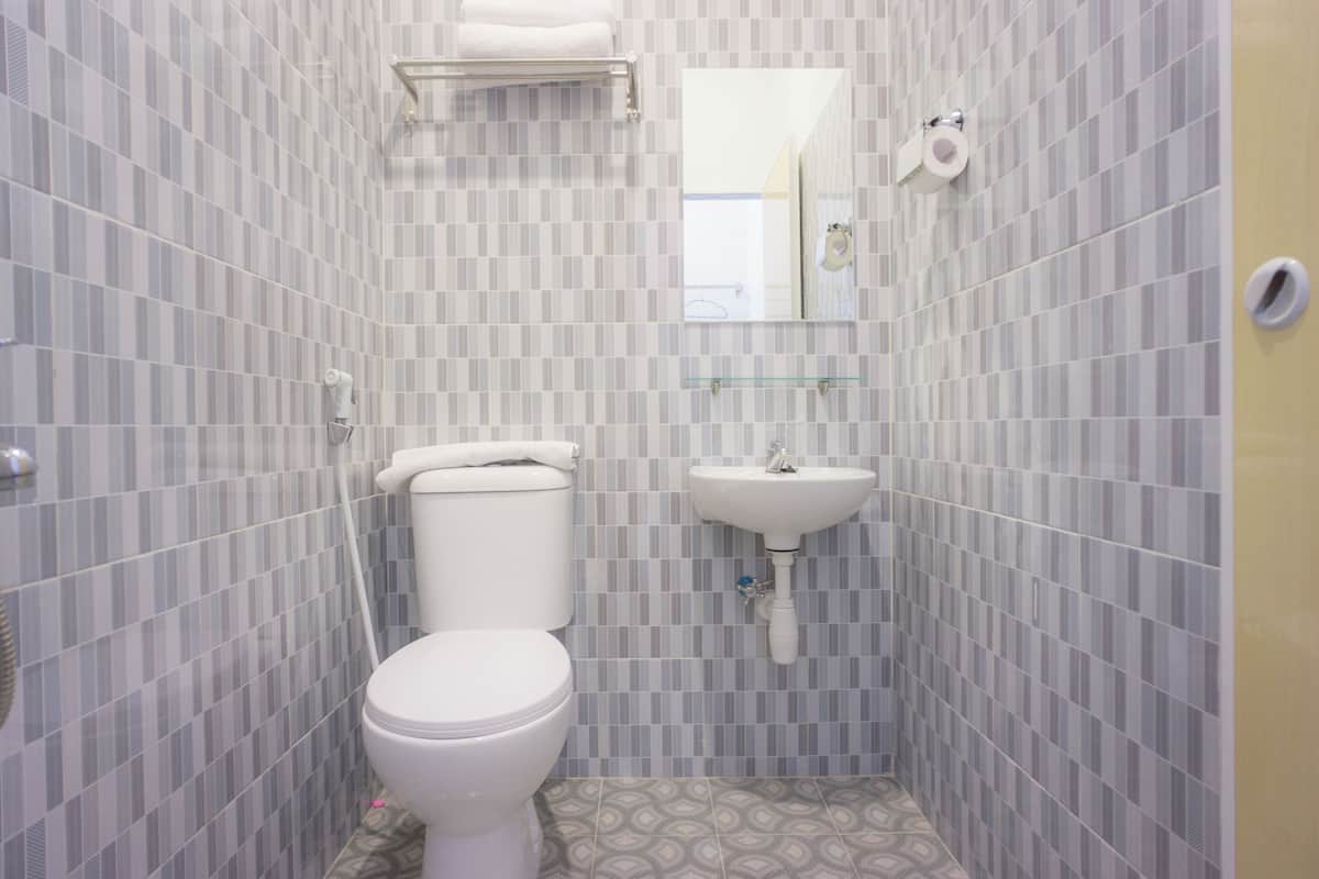 Kylpyhuone, jossa on wc, pesuallas ja peili.
