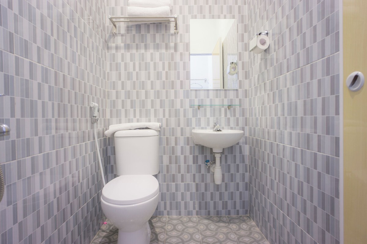 A bathroom with a toilet, sink, and mirror.