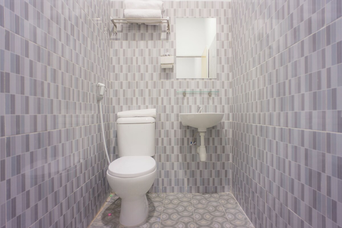 A small bathroom with a toilet, sink, and mirror.
