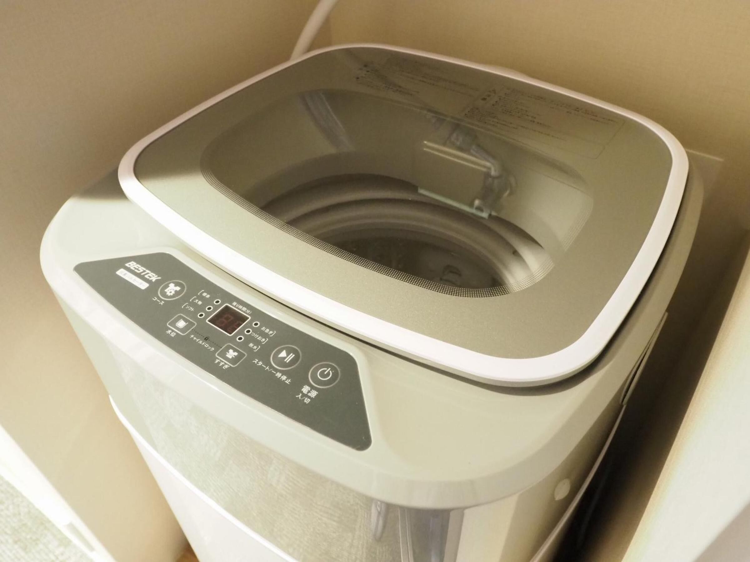 A compact, modern washing machine with a control panel featuring multiple buttons and a digital display.