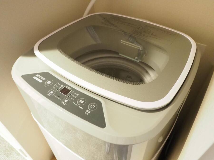 A compact, modern washing machine with a control panel featuring multiple buttons and a digital display.