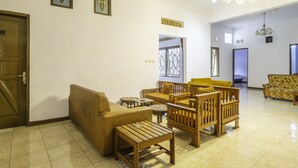 A spacious lobby with a wooden sofa, armchairs, and a coffee table. There is a door labeled '33' and a sign indicating the lobby area. - SPOT ON 2395 Hotel Aden 2 Syariah (Tasikmalaya)